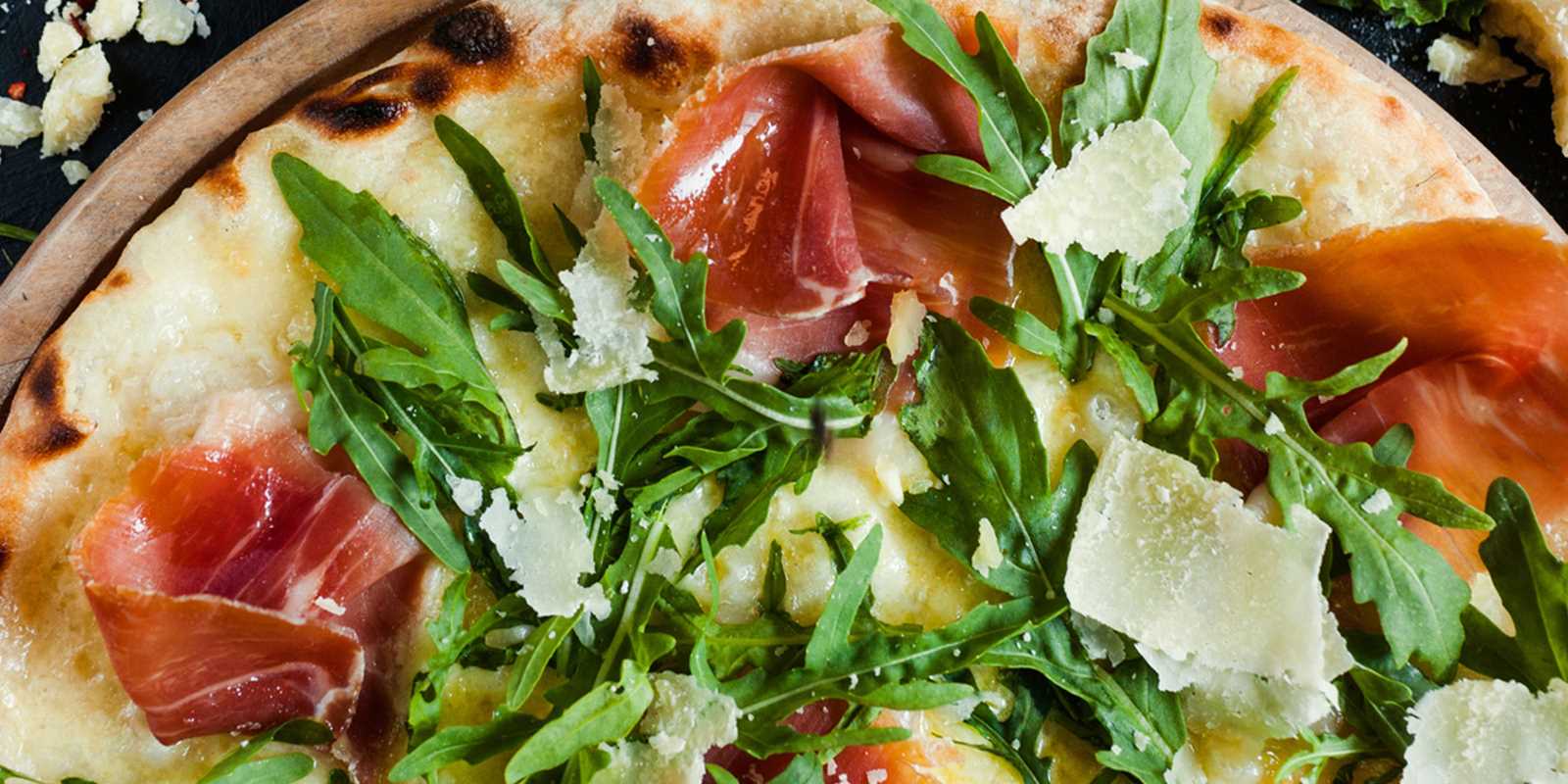 Pizza with procuito, arugula and parmesan